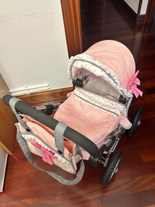 Cochecito de juguete rosa con corazones