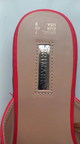 Sandalias rojas planas con hebilla dorada