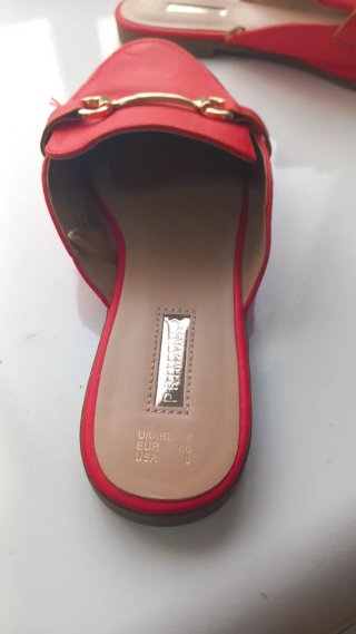 Sandalias rojas planas con hebilla dorada
