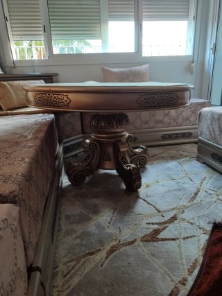 Mesa auxiliar dorada con detalles ornamentales