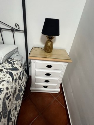 Elegante cama de matrimonio con dosel y muebles.