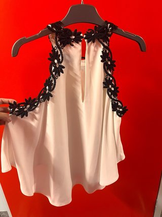 Blusa blanca con fino bordado en los bordes.