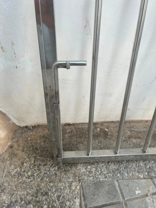 Puerta metálica con barrotes y pestillo
