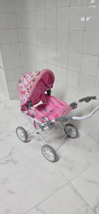 Cochecito de muñeca rosa con capota