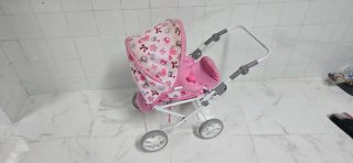 Cochecito de muñeca rosa con capota