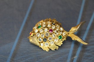 Conjunto de broche y pendientes en metal dorado y cristales.