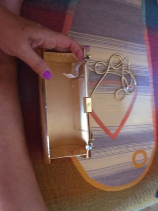 Bolso de mano dorado con cadena