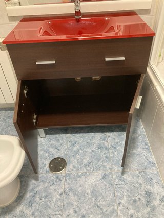 Mueble de baño con lavabo rojo y madera