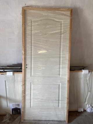 Puerta interior blanca con marco de madera