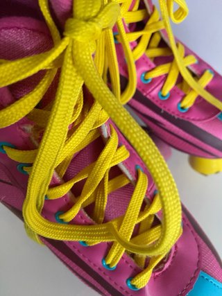 Pattini a rotelle rosa con lacci gialli