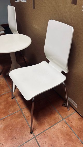 Sillas de cocina de madera blanca y mesa pequeña.