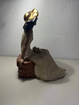 Figura mujer sentada sombrero dorado