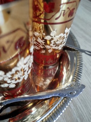 Tetera y vasos de metal y cristal