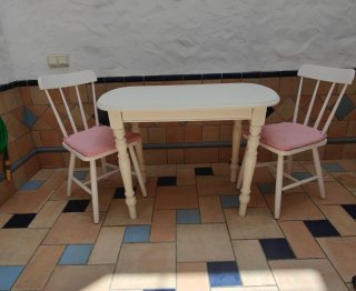Mesa y 2 sillas con cojines y ropa.RecogidaSevilla