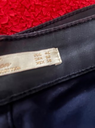 Top rojo con lazada y pantalón azul efecto cuero