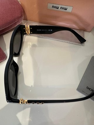 Gafas de sol Miu Miu negras y doradas