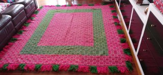 Alfombra tejida rosa y verde con flecos