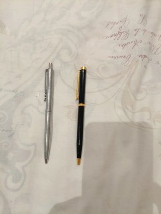 Bolígrafo plateado y negro con detalles dorados