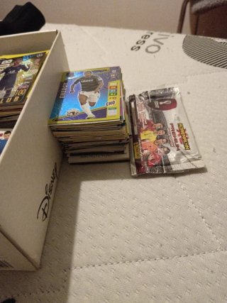 Caja de repleta de cromos de fútbol y Pokémon