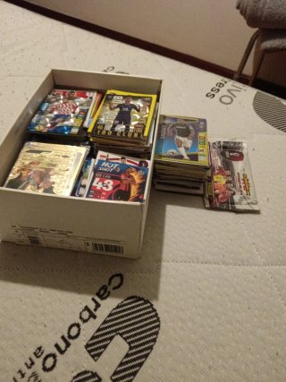 Caja de repleta de cromos de fútbol y Pokémon