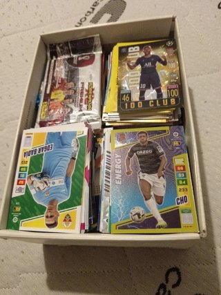 Caja de repleta de cromos de fútbol y Pokémon