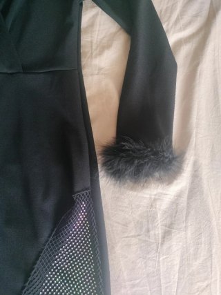 Vestido negro elegante con plumas y rejilla