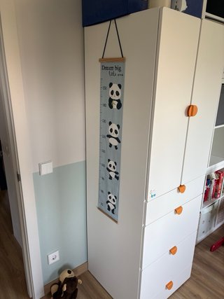 Armario infantil blanco con pomos naranjas.