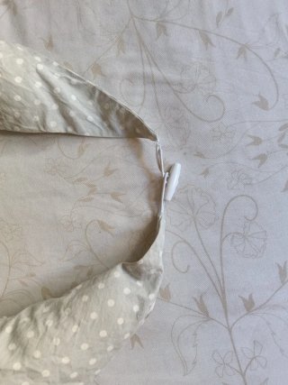 Cojín de lactancia gris con puntos blancos