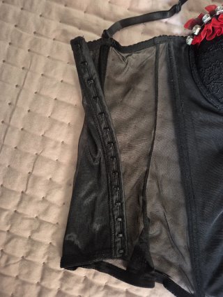 Corsé negro con pedrería y detalles rojos.