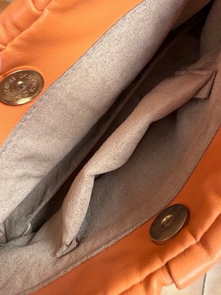 Bolso naranja con cadena dorada