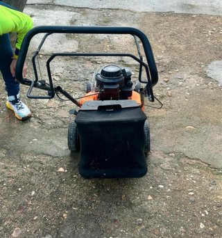 Cortacésped naranja con bolsa recolectora