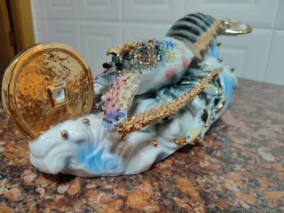 Figura langosta cerámica con moneda dorada