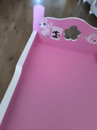 Cuna de juguete rosa para muñecas. Juguetos