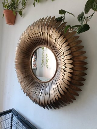 Espejo de pared dorado con diseño de plumas