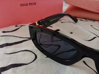 Gafas de sol Miu Miu negras y doradas