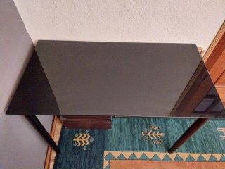 Mesa de cristal oscuro con patas de metal