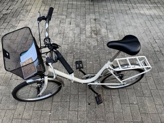 Bicicleta plegable blanca con cesta
