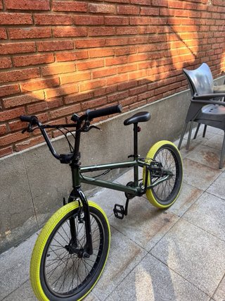 Bicicleta BMX verde con ruedas amarillas