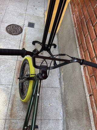 Bicicleta BMX verde con ruedas amarillas