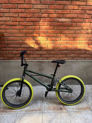 Bicicleta BMX verde con ruedas amarillas