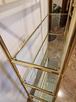 Estantería dorada con baldas de cristal