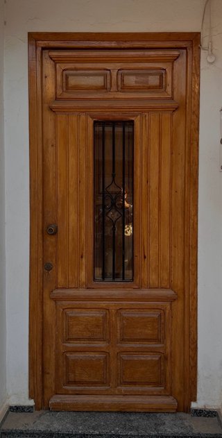 Puerta de madera maciza con cristal.