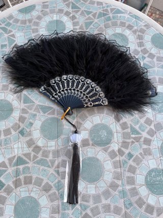 Abanico negro con plumas y detalles dorados