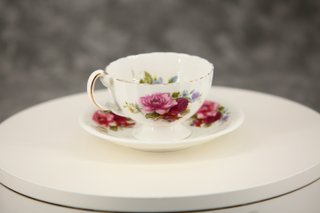 Taza de té y plato de porcelana con rosas