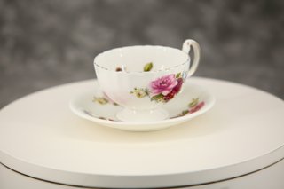 Taza de té y plato de porcelana con rosas