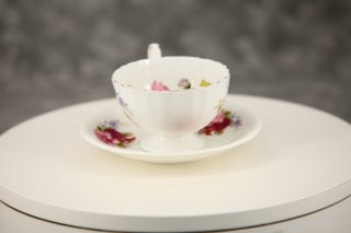 Taza de té y plato de porcelana con rosas