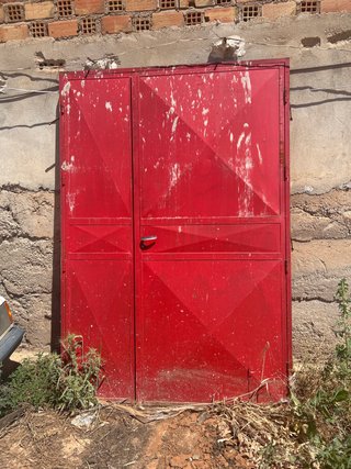 Puerta metálica exterior roja.
