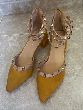 Zapatos de tacón con tachuelas doradas