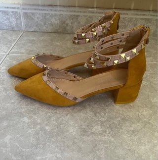 Zapatos de tacón con tachuelas doradas