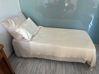 Cama individual Zara Home con ropa y cojines